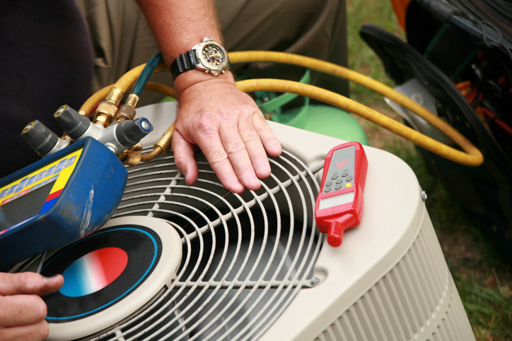A technician performing maintenance on an hvac unit